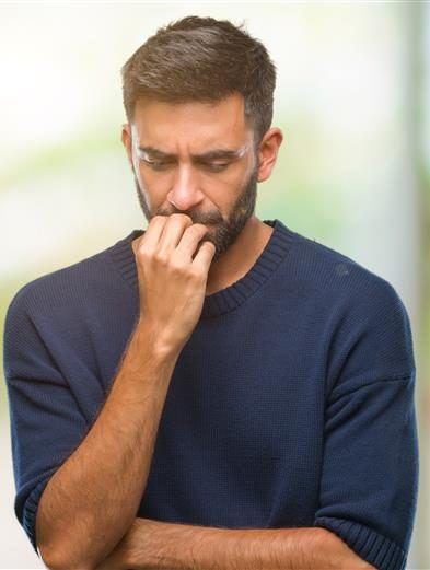 Hombre preocupado reflexiona sobre su salud y el riesgo de VPH en hombres.